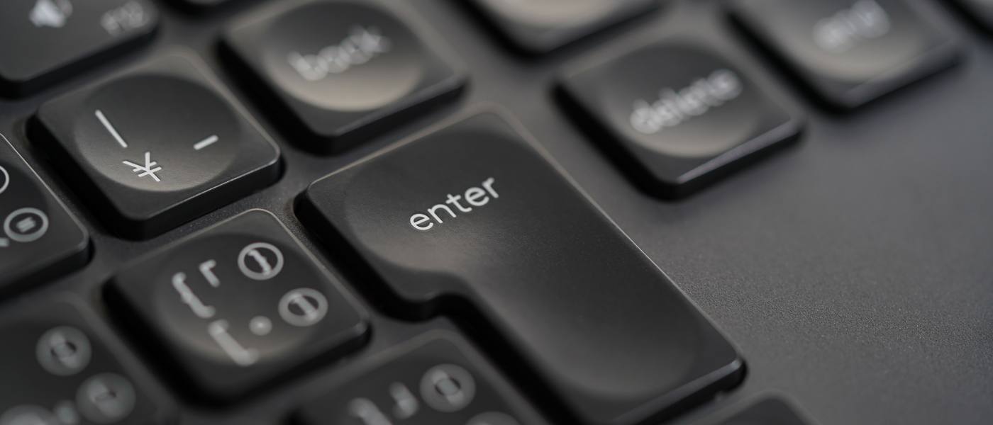 Primer plano de la tecla Enter en un teclado negro, lista para enviar tu mensaje