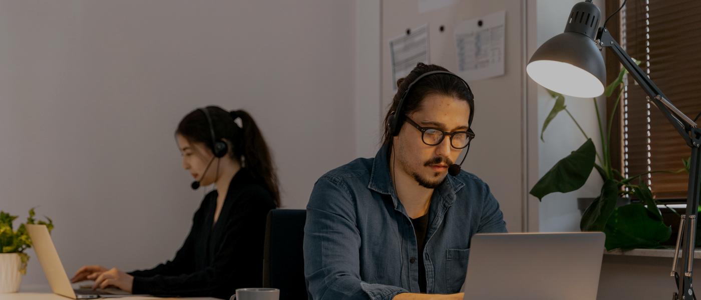 Equipo comercial con diademas atendiendo clientes desde sus computadores, haciendo seguimiento a cada mensaje que entra